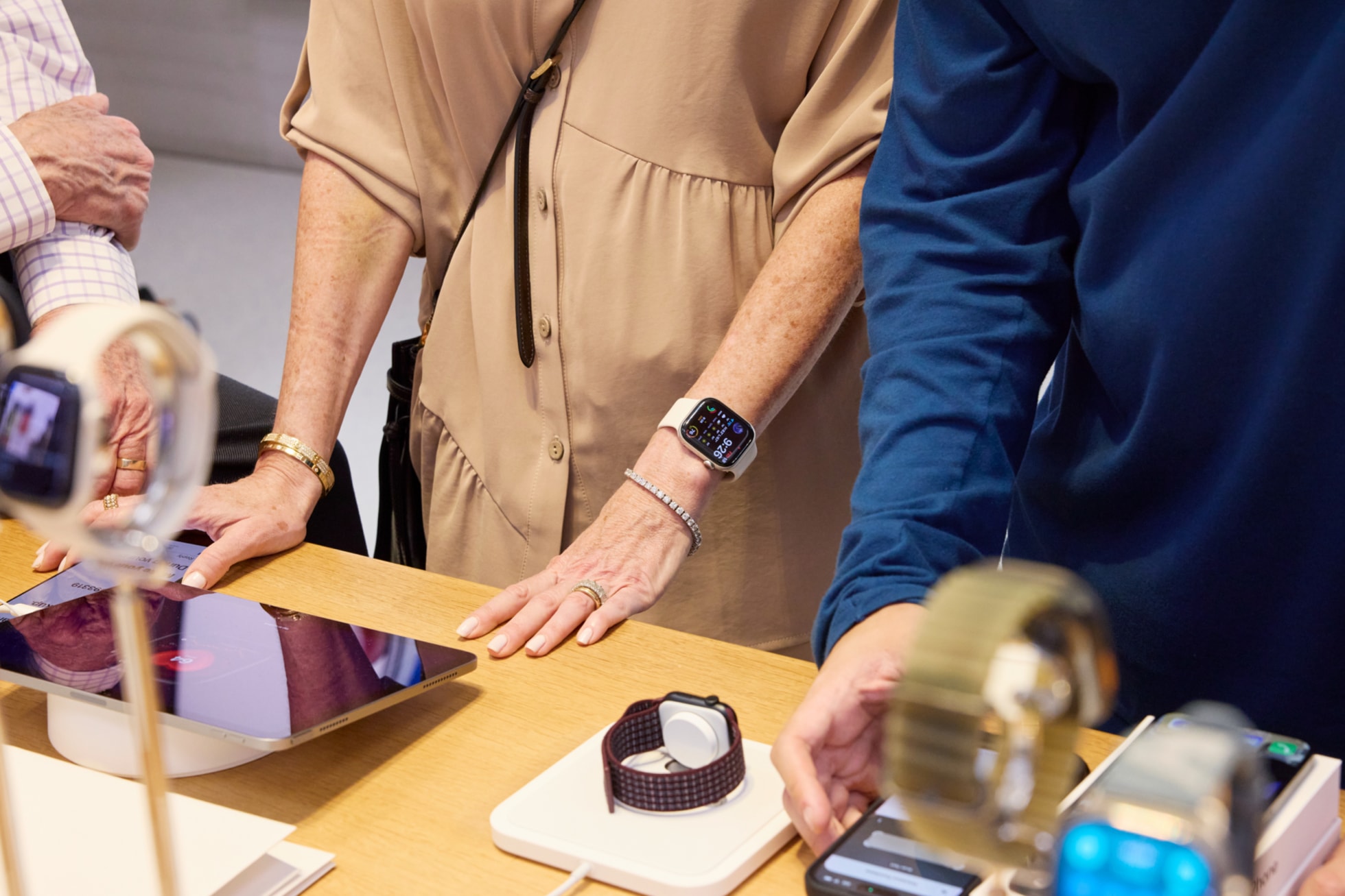 Zaměstnanec Applu pomáhá zákaznici s výběrem Apple Watch