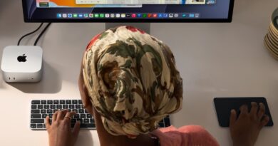 Mac mini na pracovním stole vedle klávesnice a displeje