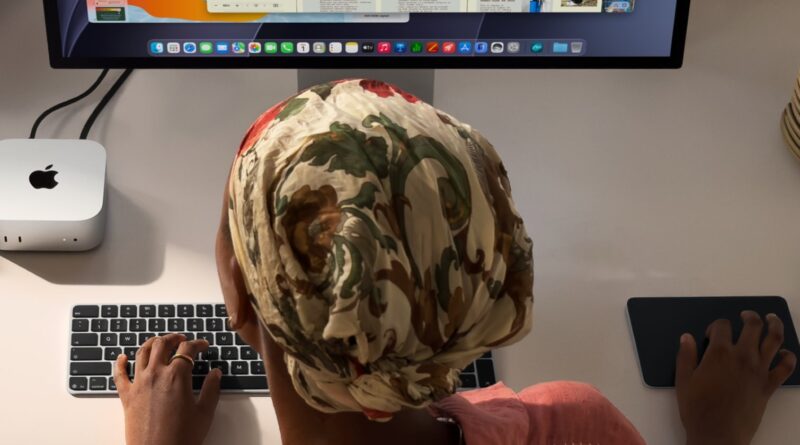 Mac mini na pracovním stole vedle klávesnice a displeje