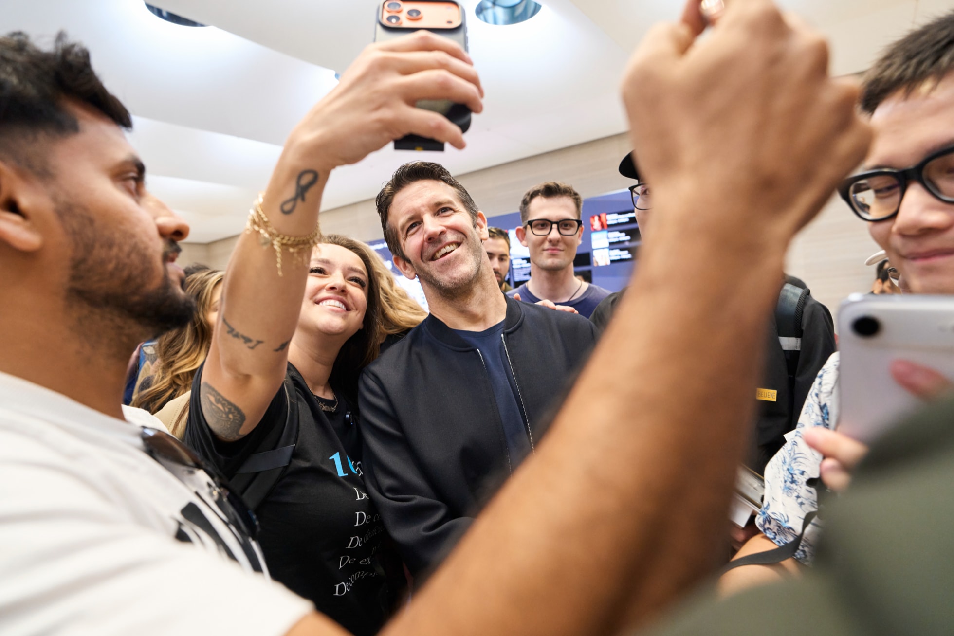 John Ternus se fotí se zákazníky v Apple Storu