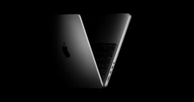 MacBook Pro v tmavém nasvícení s pootevřeným víkem