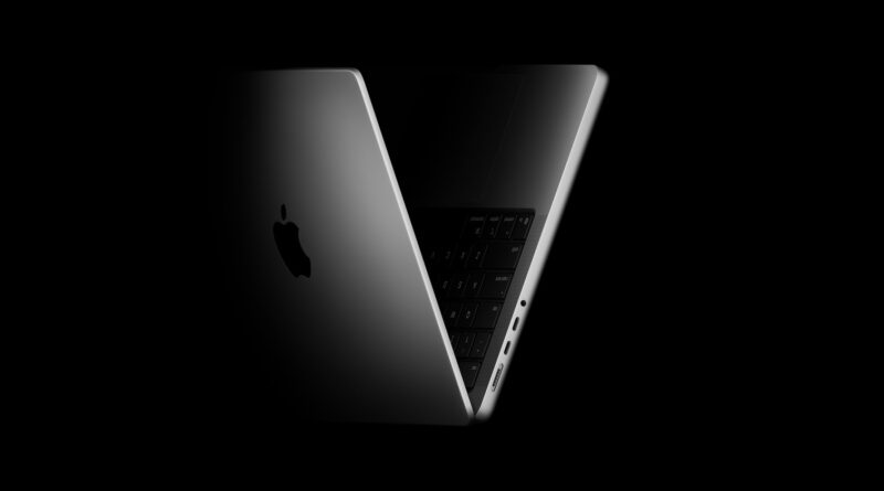 MacBook Pro v tmavém nasvícení s pootevřeným víkem