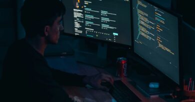 Programátor u monitorů s kódem v setmělé místnosti