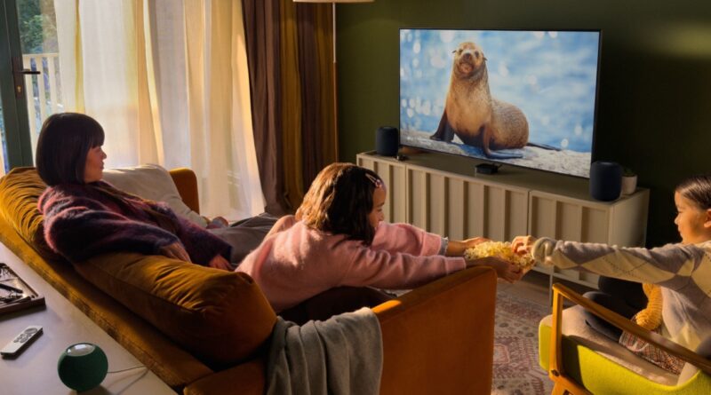 Rodina sleduje televizi s novou Apple TV 4K a reproduktory HomePod mini