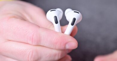 Ruka držící dvě sluchátka AirPods Pro 3