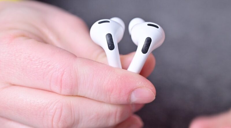 Ruka držící dvě sluchátka AirPods Pro 3