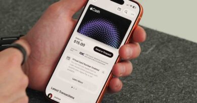 Ruka držící iPhone s otevřenou kartou Apple Cash v Peněžence