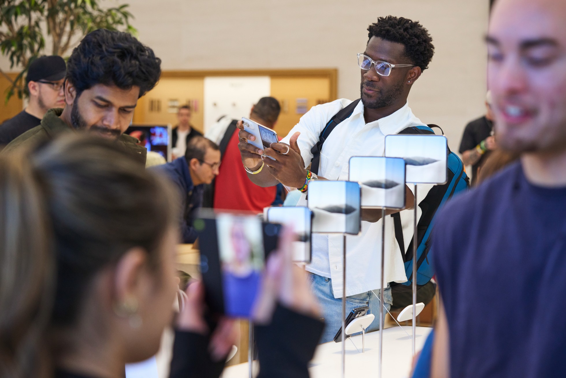 Zákazníci zkoušejí iPhone Duo u předváděcího stolku v prodejně Applu v Austinu