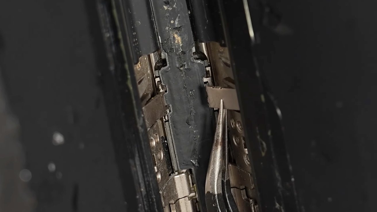 Detail poškozeného pantu iPhonu Duo