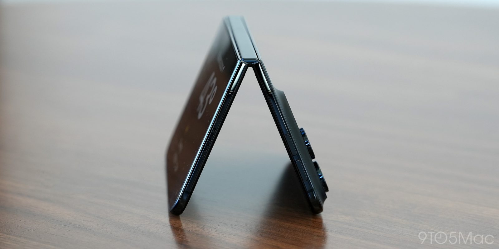Pootevřený iPhone Duo stojící na stole, pohled na pant