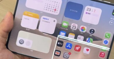 Rozložený iPhone Duo v ruce s prasklinou vedoucí podél pantu displeje