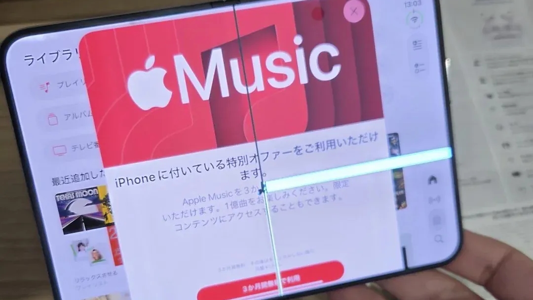 Prasklý vnitřní displej předváděcího iPhonu Duo v prodejně se spuštěným Apple Music