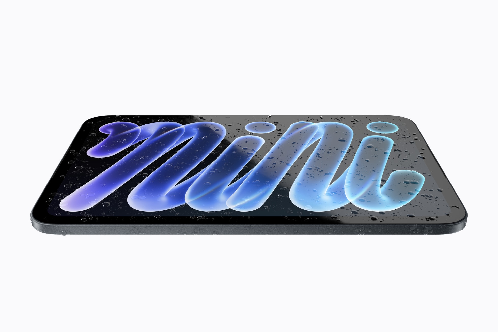 iPad mini ležící na stole pokrytý kapkami vody