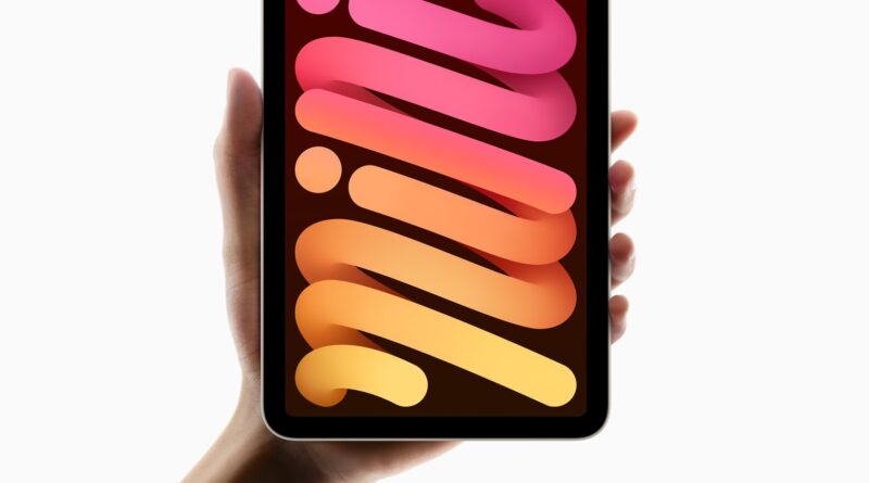 Ruka držící iPad mini s barevnou tapetou