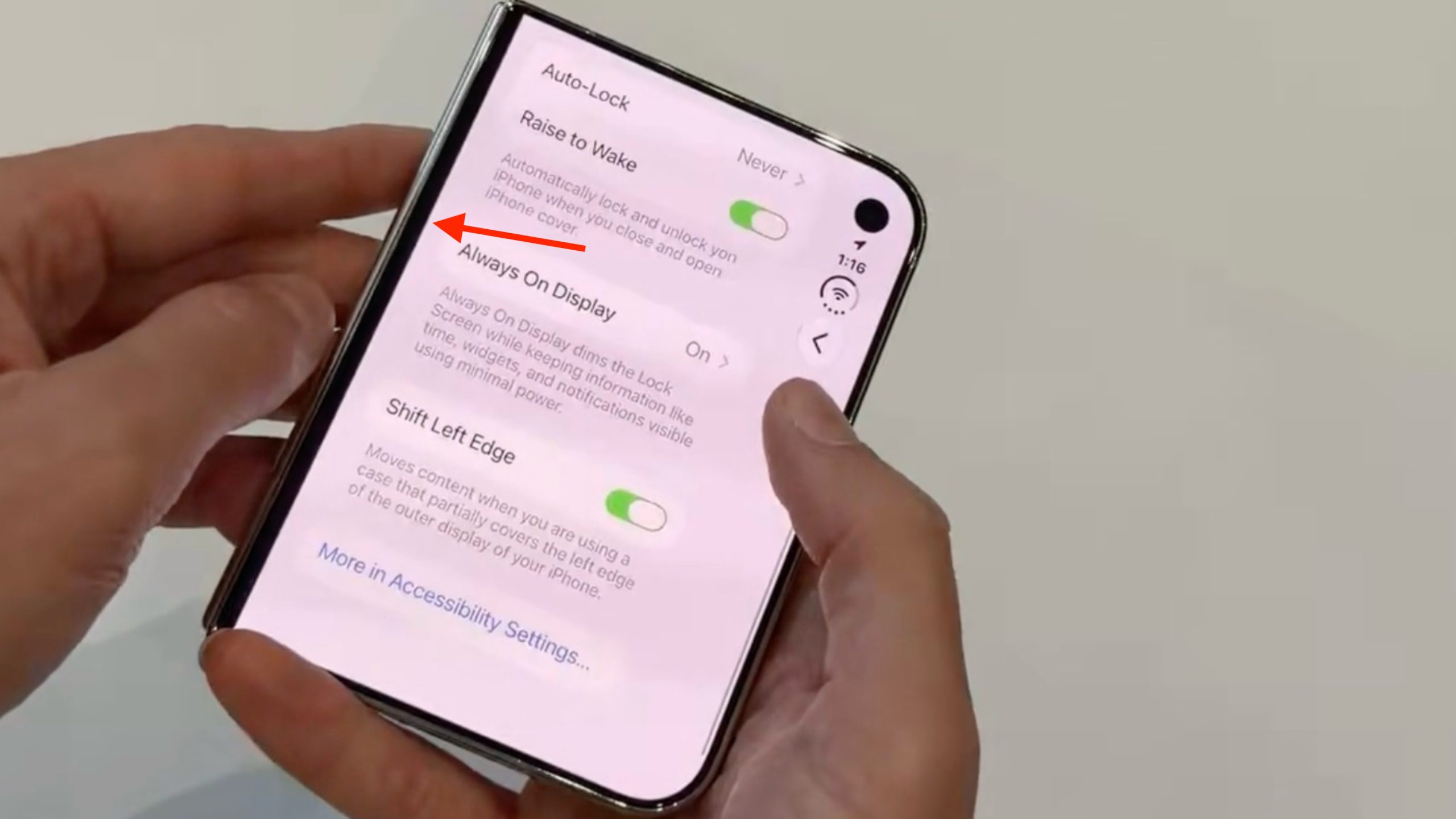 iPhone Duo držený v ruce s otevřeným nastavením displeje