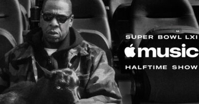 JAY-Z v hledišti stadionu vedle loga Apple Music Super Bowl LXI Halftime Show