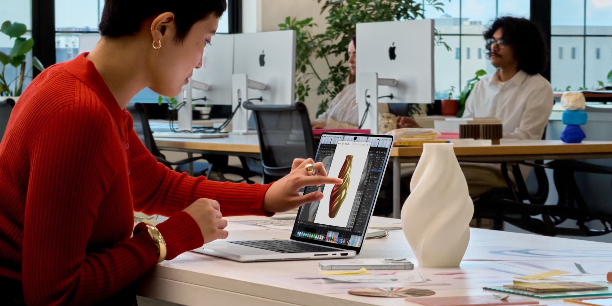 Žena pracující u stolu s dotykovým MacBookem Pro