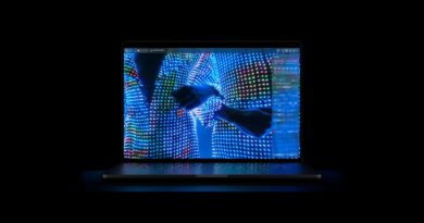 MacBook Pro s OLED displejem na tmavém pozadí