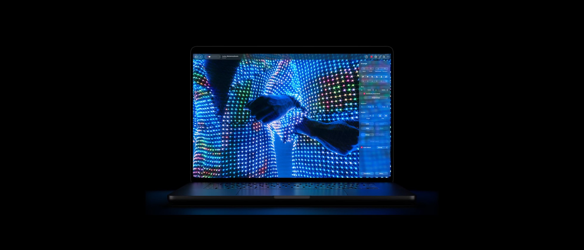 MacBook Pro s OLED displejem na tmavém pozadí