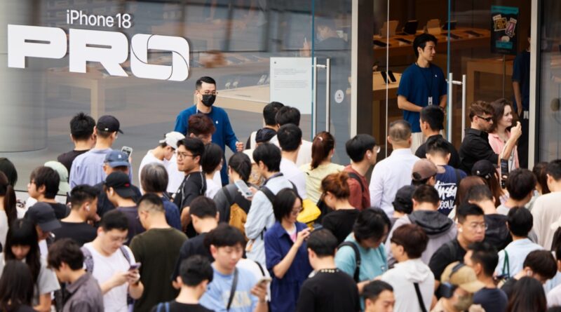 Dav zákazníků před obchodem Apple Store s polepem iPhone 18 Pro
